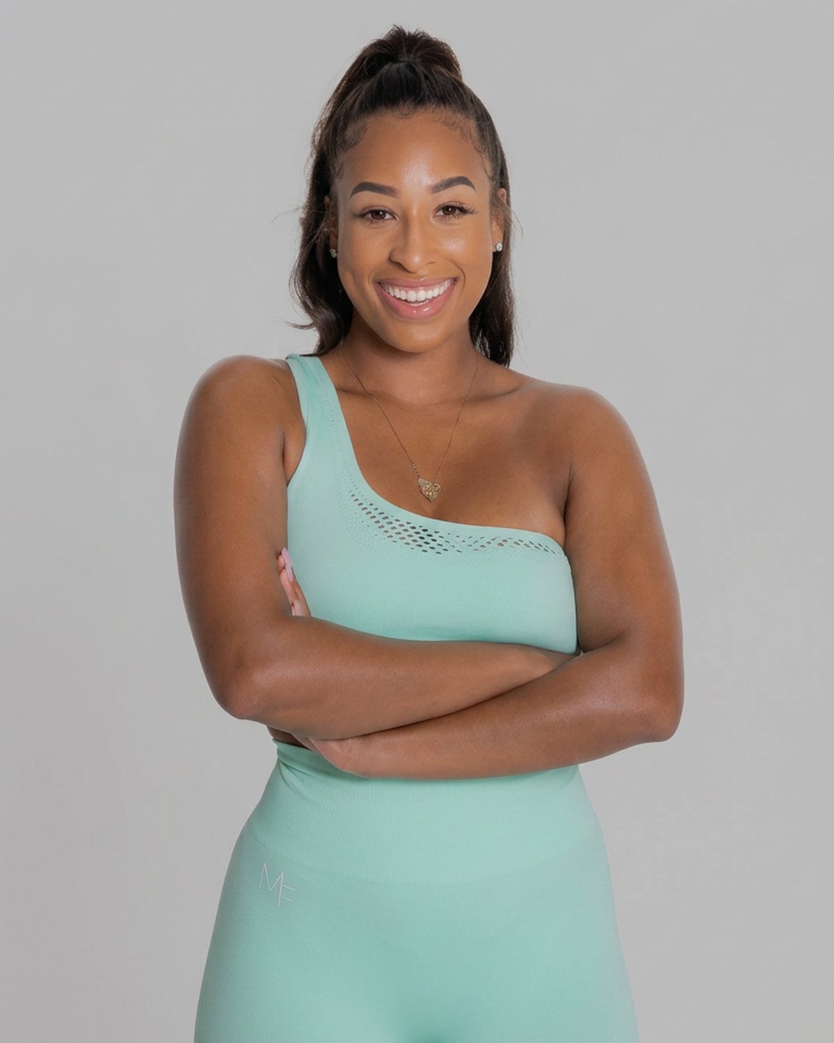 Personal trainer Kayla Waller smiling in a teal athletic top at FLEX